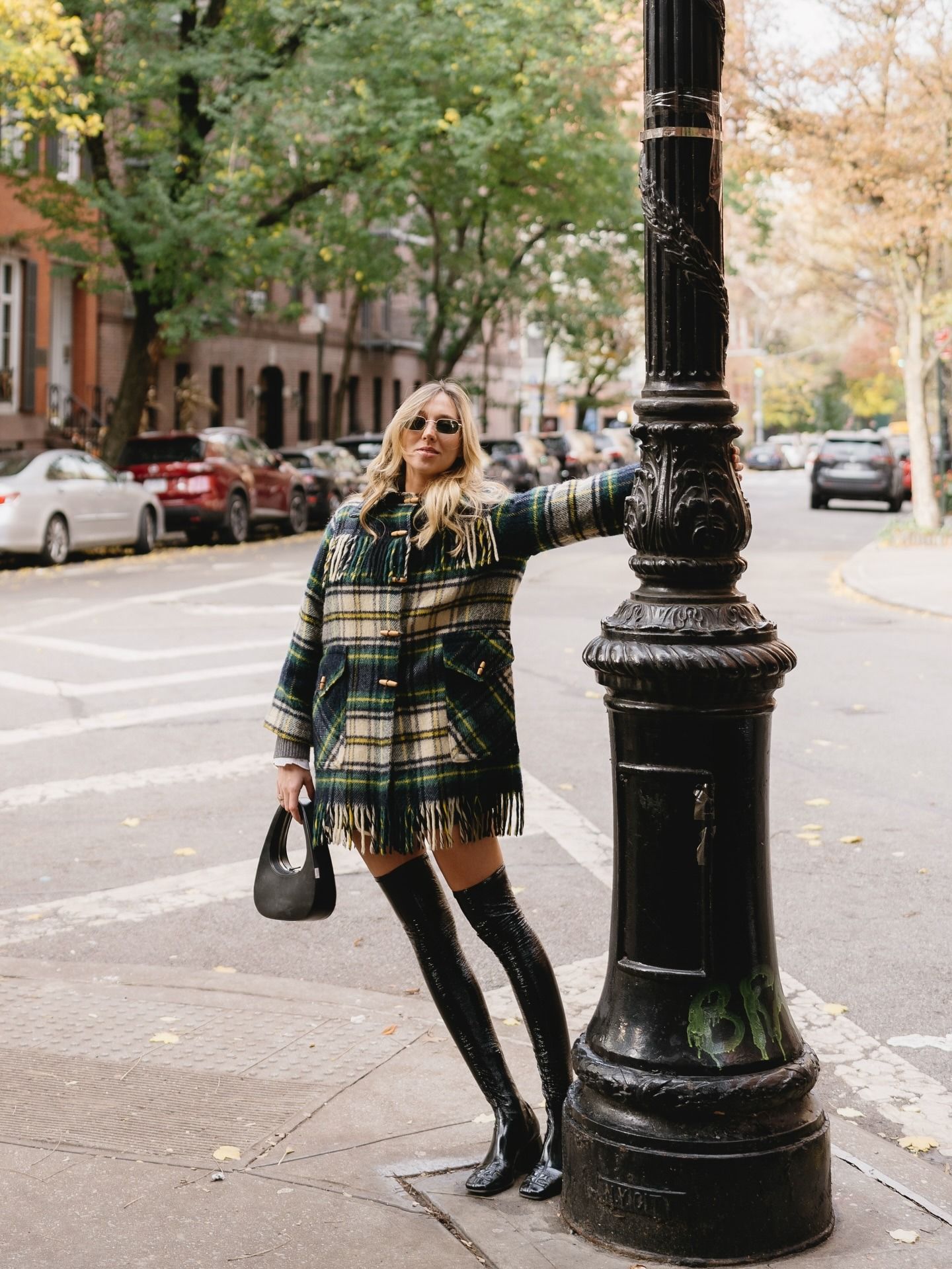 Maggie Klimuszko in a short plaid coat with over-the-knee boots.