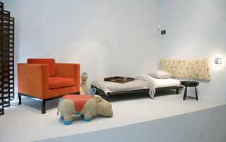 Room includes bed, chair, table, rhino stool