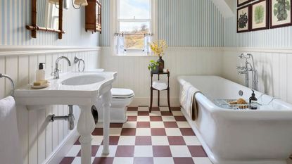 A bathroom with a red and white chequered floor, a bath and sink