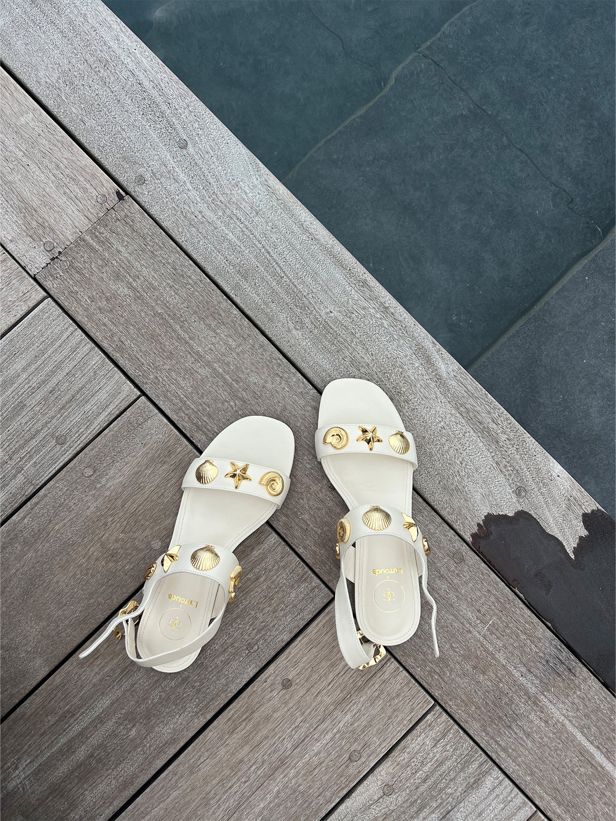 White Larroudé x Rosewood Le Guanahani flat sandals.