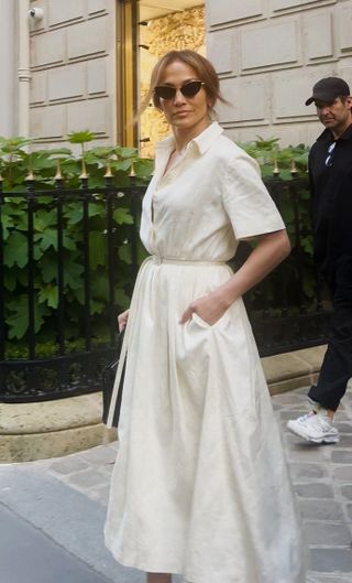 Jennifer Lopez in Paris wearing a ivory shirtdress, and cat-eye sunglasses.