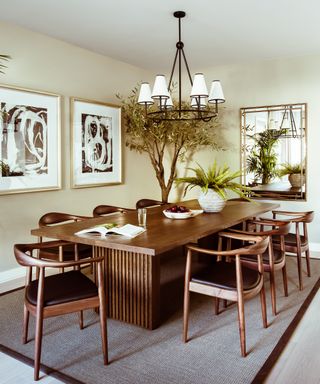 A dining room with neutral walls and a wooden dining table and chairs