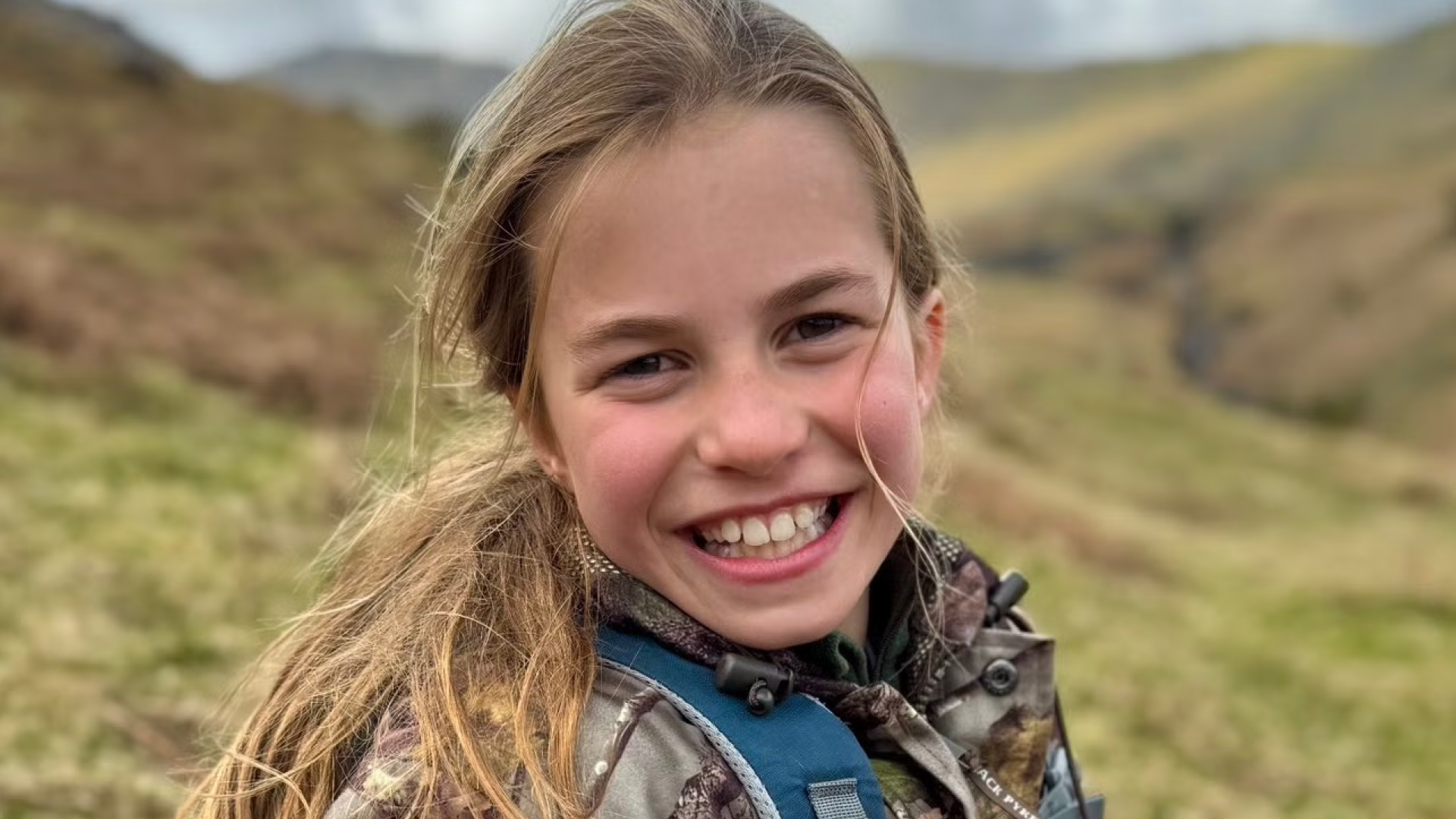 Princess Charlotte smiling wearing a camouflage Jacket on her 10th birthday