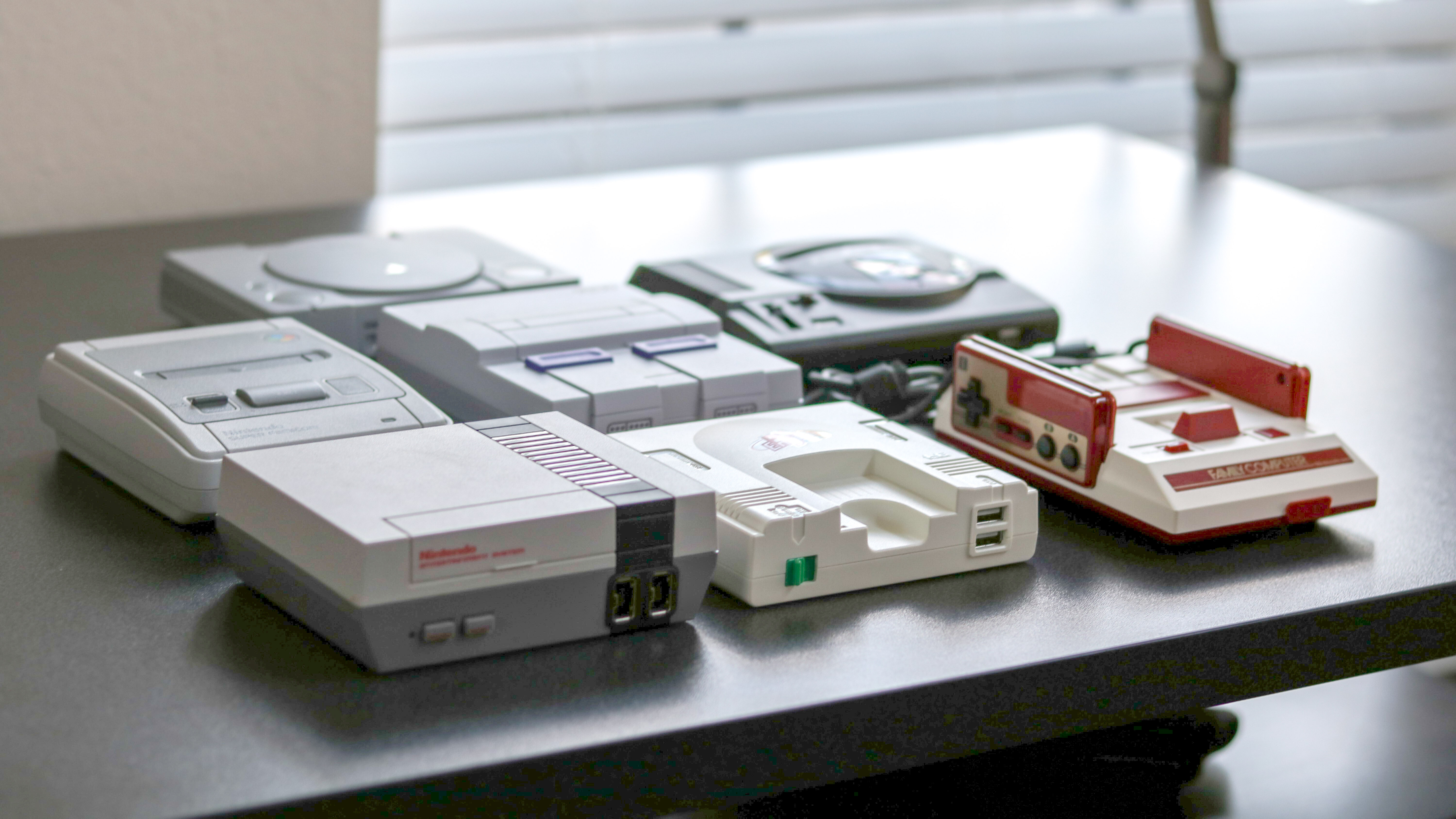 A collection of mini consoles on a desk