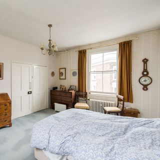 bedroom with white wall and wooden drawer