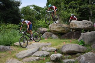 Top men's contenders for gold include Tokyo Olympic Games winner Tom Pidcock of Great Britain (left), and Swiss riders Nino Schurter (centre) and Mathias Flückiger (right)