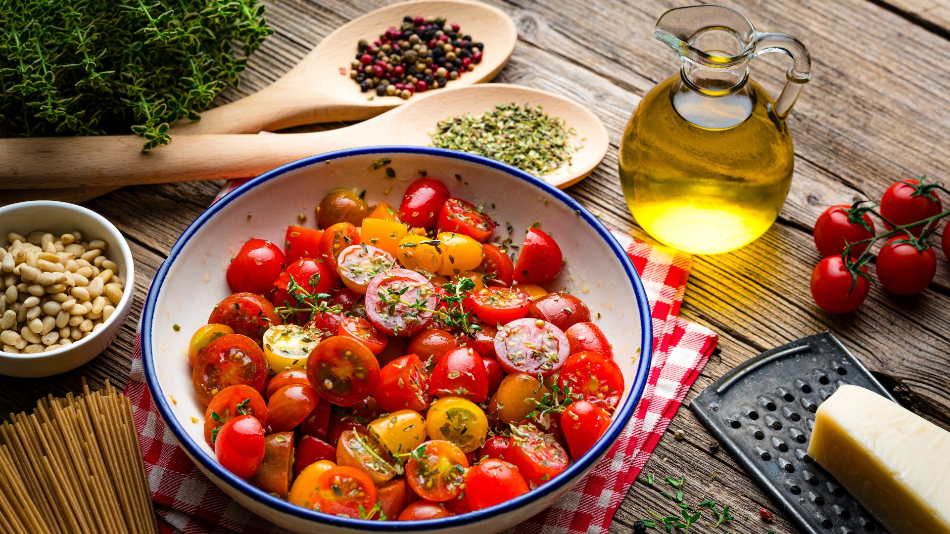 Tomatoes in a bowl with olive oil, wholegrain pasta and herbs, part of the Mediterranean diet