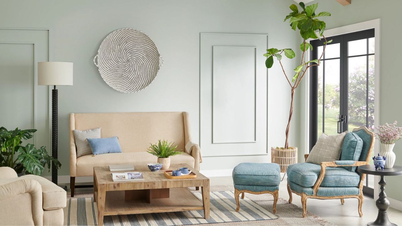 living room with light green-gray walls and modern light wood furniture and houseplants