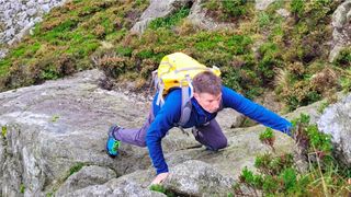 Rock climbing man wearing Sea to Summit Flow 35L Dry Pack