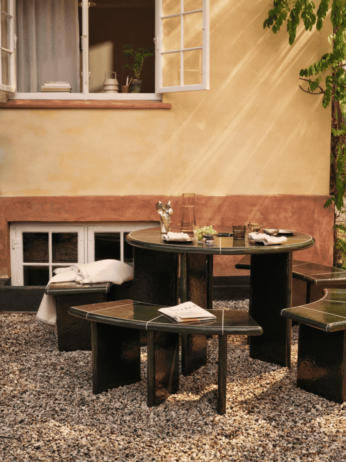 a rotating gif of a green round dining table and a undulating bench