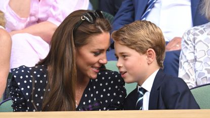 Prince George smiles in a suit and tie in the Royal Box at Wimbledon