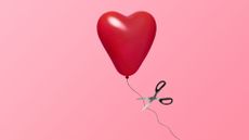 Heart balloon being cut with metallic scissors, representing how to handle a breakup