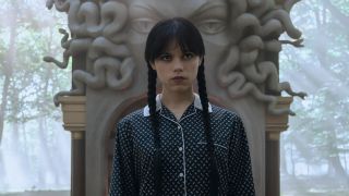 Wednesday in front of Medusa-shaped fireplace outdoors in Wednesday Season 2