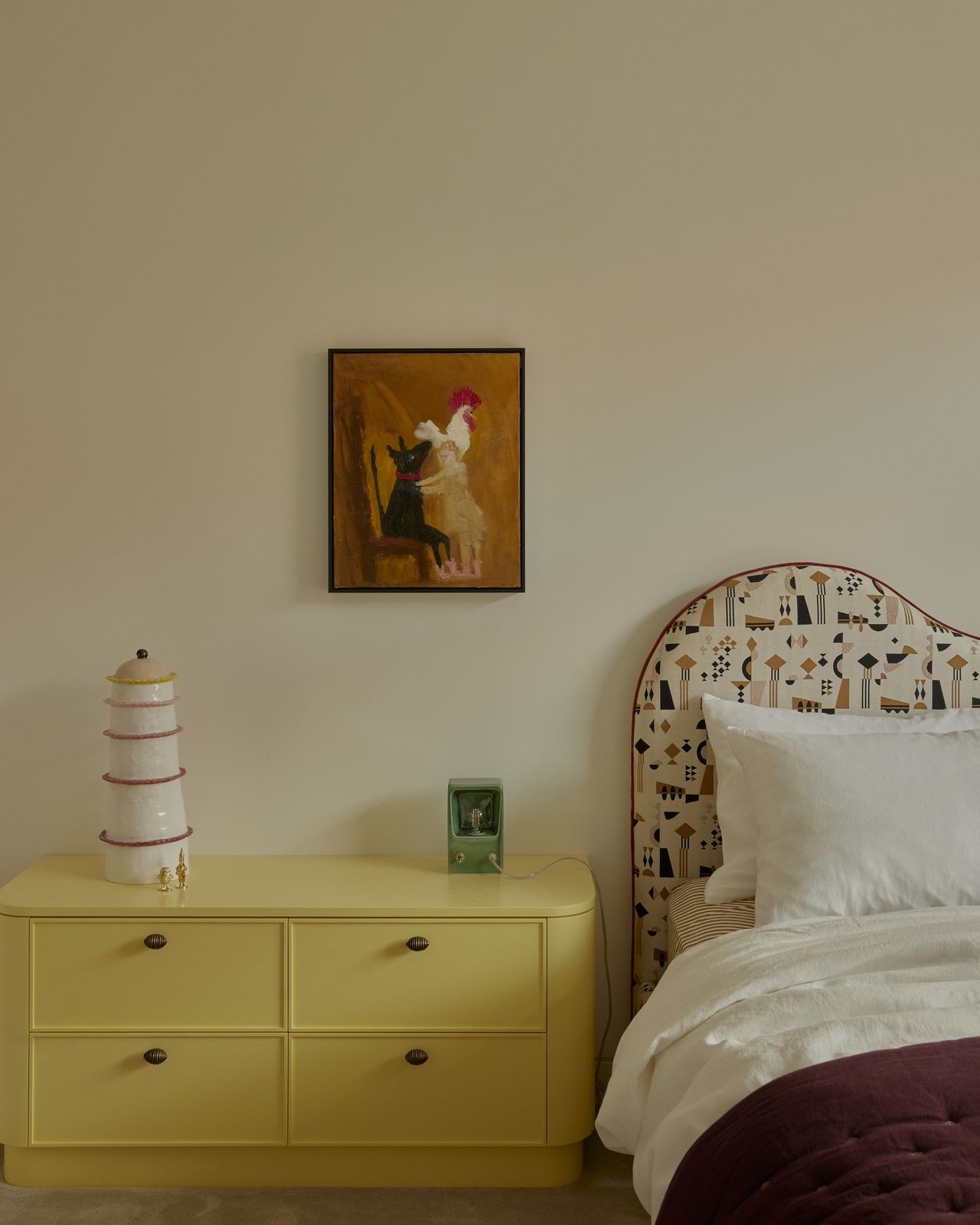 kids bedroom with colorful headboard, purple bedcover, artwork, and yellow bedside table
