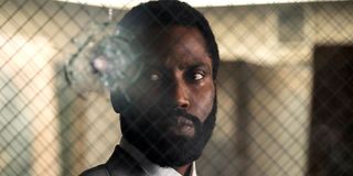 Tenet John David Washington looking at a bullet hole in a window