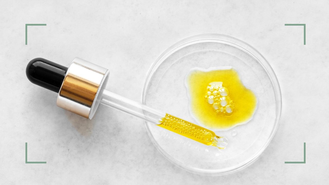 A pipette of evening primrose oil with a dish on a marble backdrop