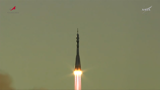 A rocket launches against a chartruce colored sky