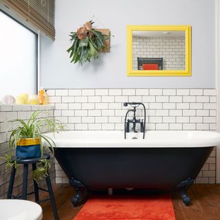 bathroom with wooden floor and black coloured bathtub