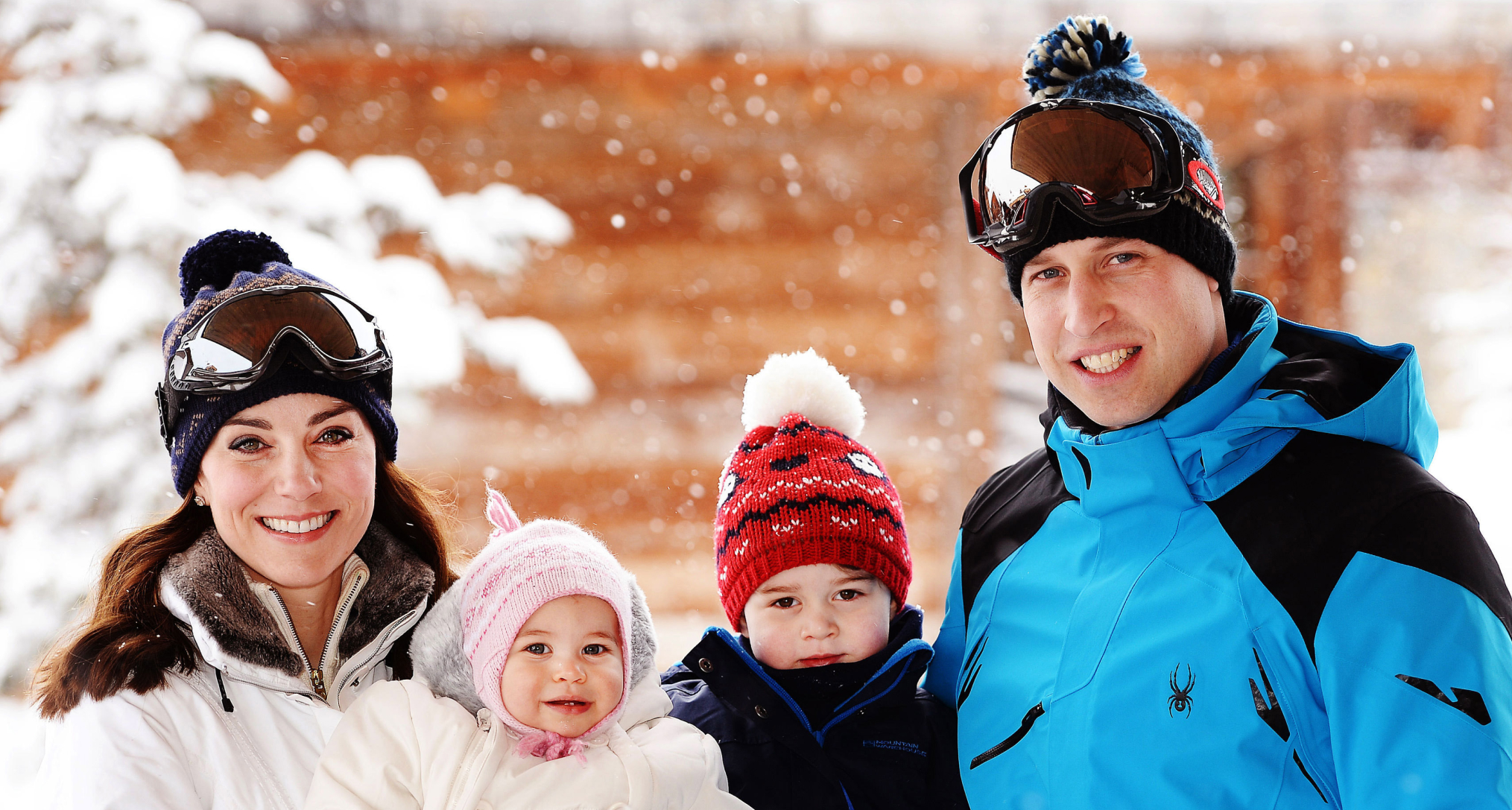 Princess Kate, Prince George, Princess Charlotte, Prince William posing in ski gear in front of a snowy tree