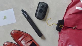 An Insta360 One X2 camera lying among a suit and shoes