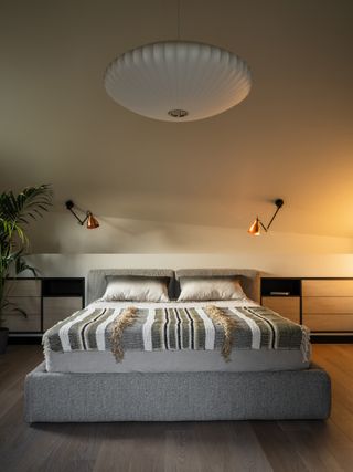 A bedroom with a mood lighting pendant above