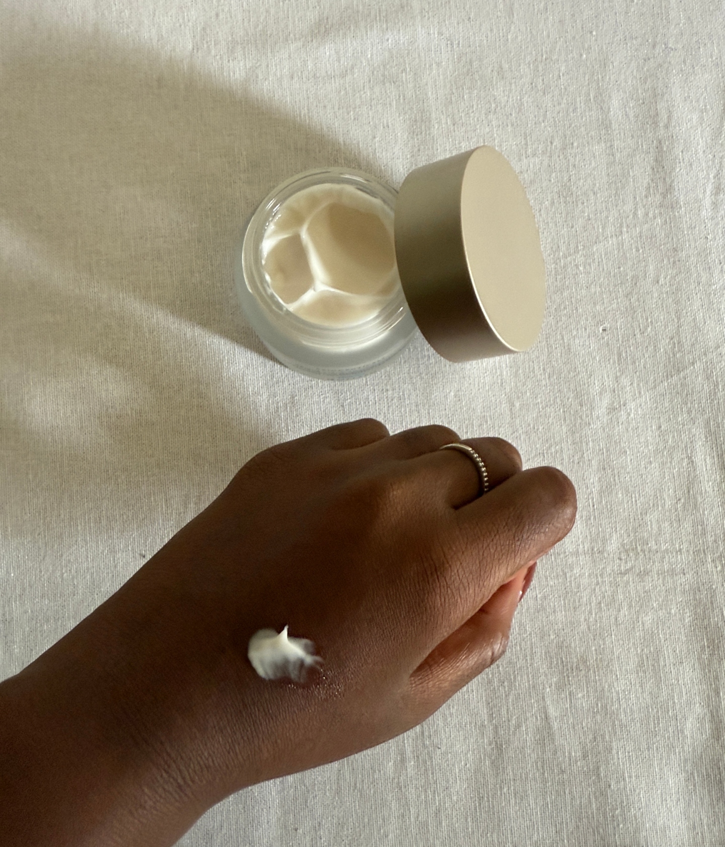 Associate Beauty Editor Maya Thomas with the SkinCeuticals Triple Lipid Restore 2:4:2 Moisturizer Cream on the back of her hand