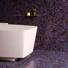 bathroom with tiles on wall and white bathtub