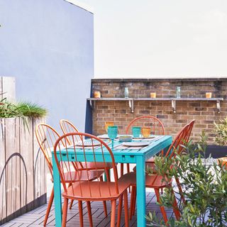 Balcony with blue feature wall and colourful dining set