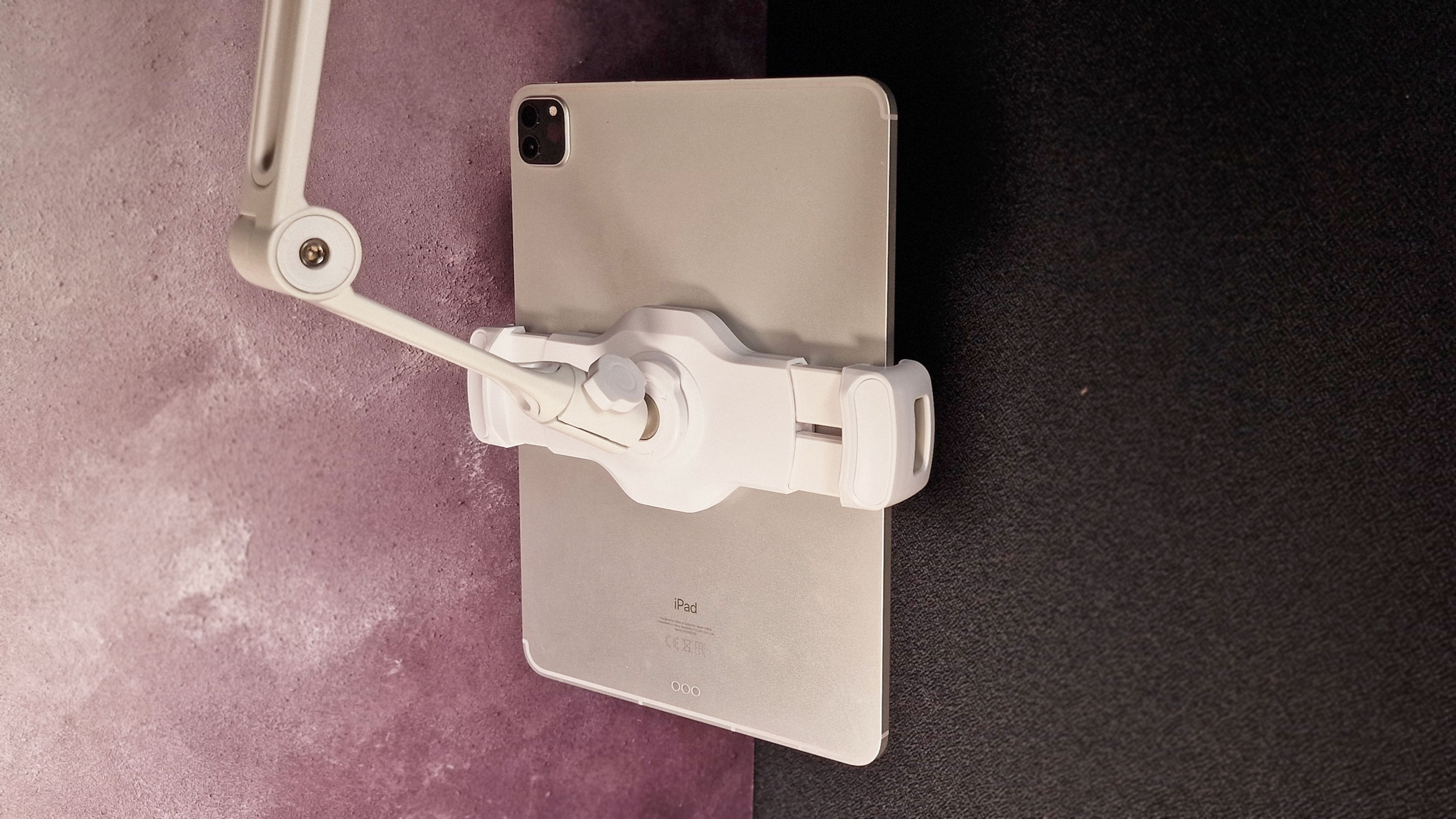 A photo of the HoverBar Duo stand with an iPad in it against a dark background