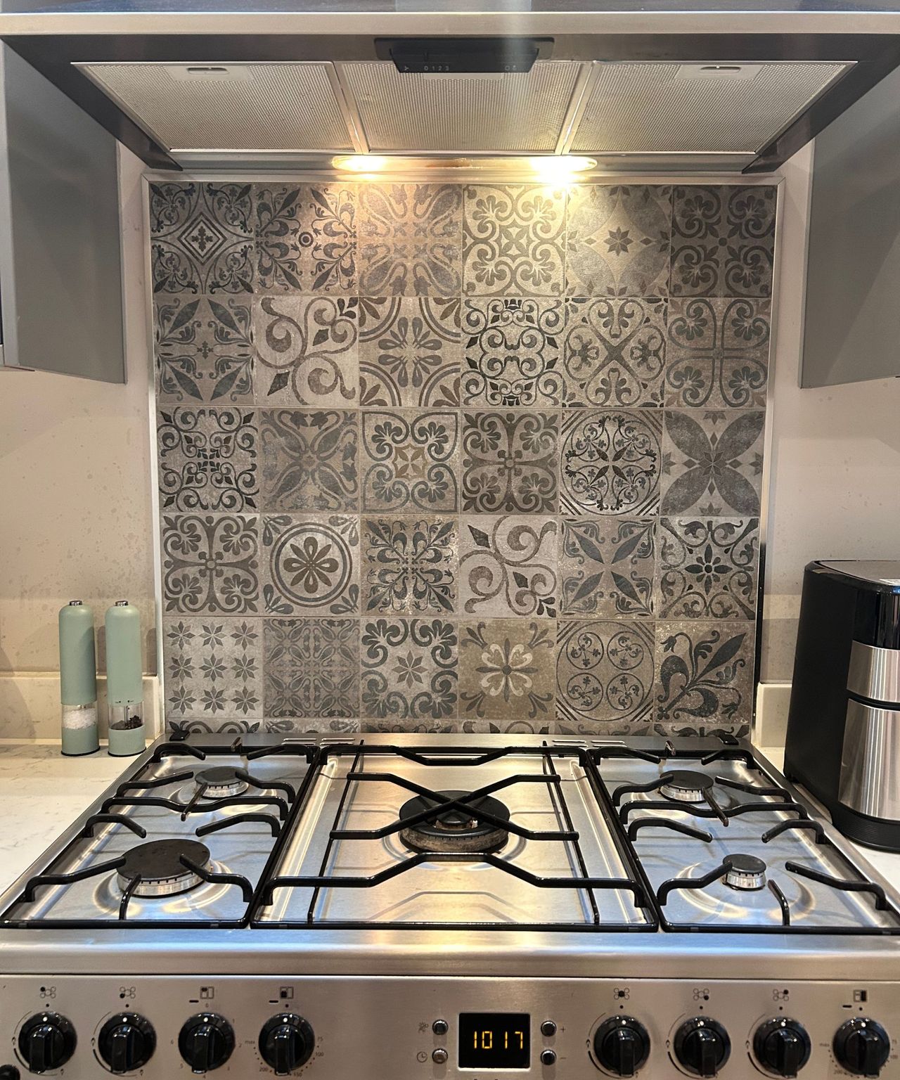 Grey and white tiled splashback with a sparkly silver hob