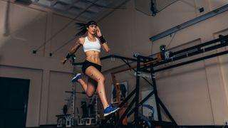 Female athlete with motion capture sensors on her body running in biomechanical lab