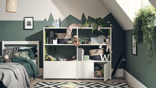 green kids room with white open shelving near single bed