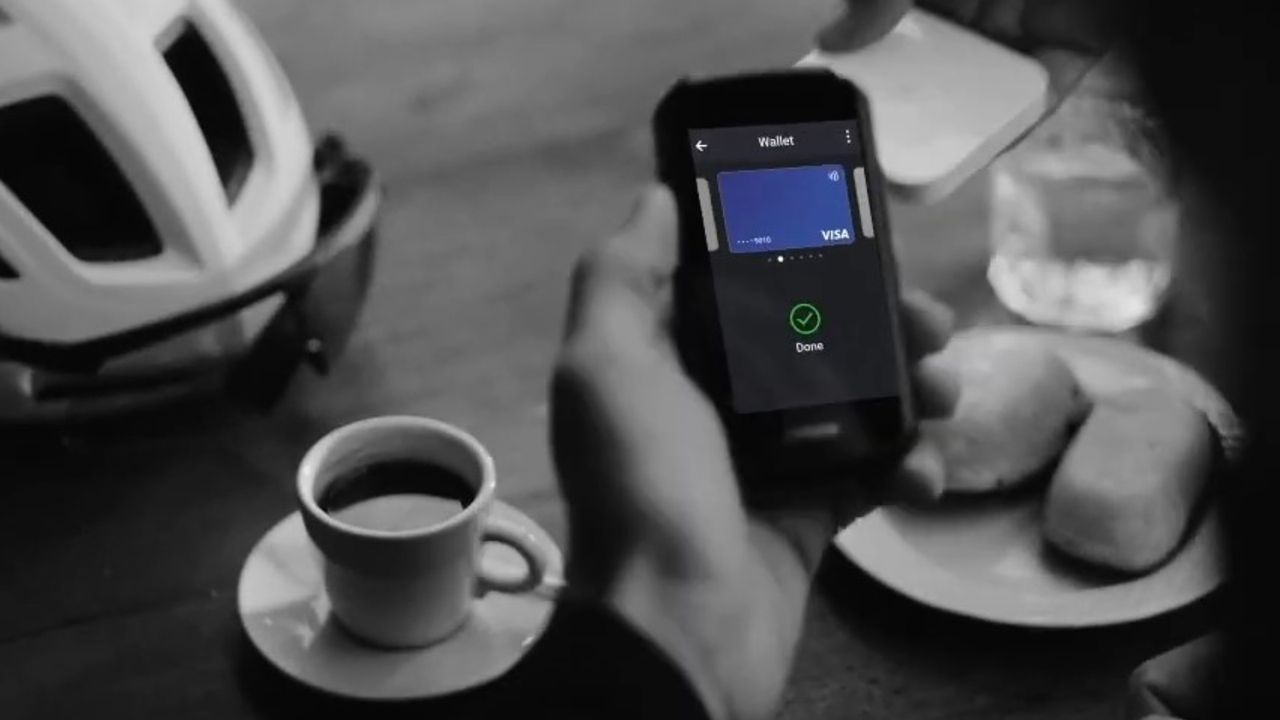 The Garmin Edge 1050 being used to pay for the coffee on the table 