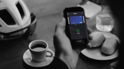 The Garmin Edge 1050 being used to pay for the coffee on the table 