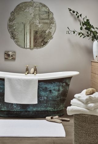 white towels and verdigris bath with antique mirror