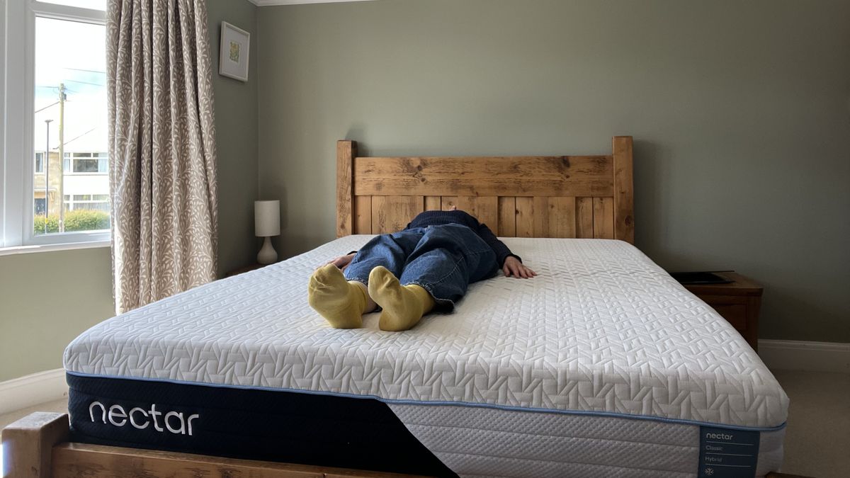 reviewer lying on her back to test the nectar classic hybrid