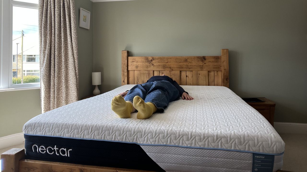 reviewer lying on her back to test the nectar classic hybrid