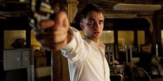 Robert Pattinson aiming a gun in Cosmopolis