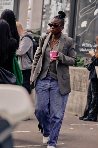 Nikki Ogunnaike wearing blue wide-leg jeans, a gray vest, and a gray blazer at Paris Fashion Week