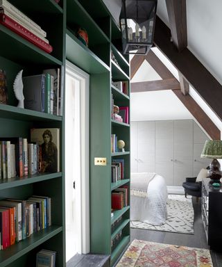 colors that go with dark green, hallway with dark green bookcase on the left, bedroom at end, beams, rugs