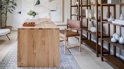 A home office with shelving and a solid wooden desk 