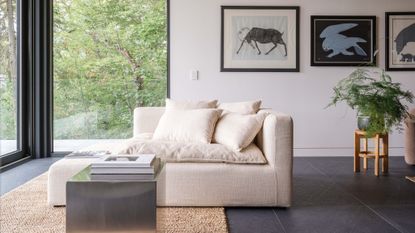 Minimalist reading corner in cream by large window s overlooking nature