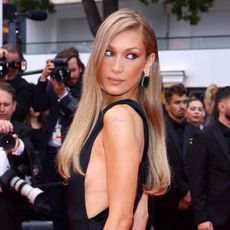 a woman with golden blonde hair standing in front of a crowd of paparazzi