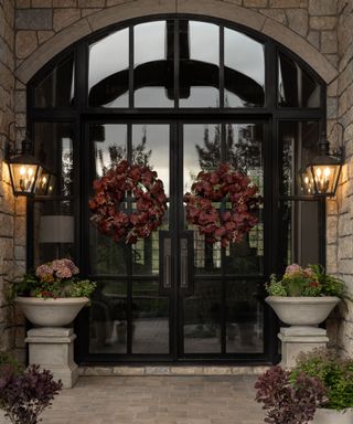 A large glass front door decorated for fall