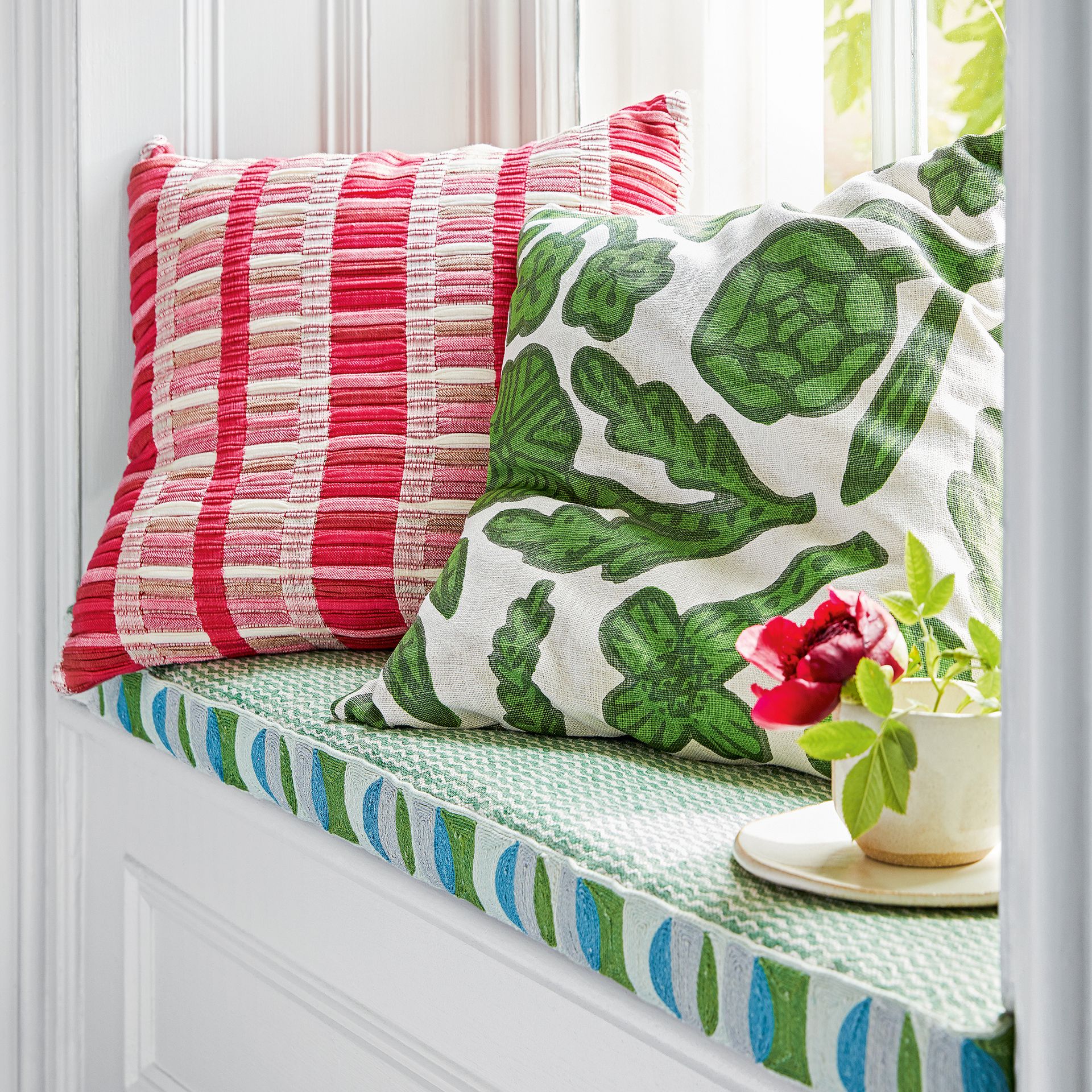 Window seat with upholstered cushion and two scatter cushions