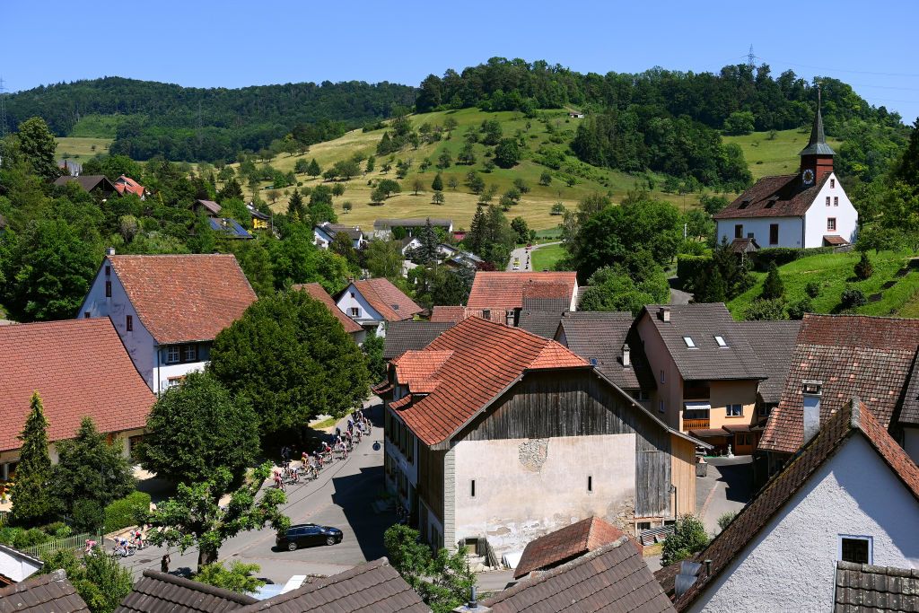 AESCH SWITZERLAND JUNE 13 A general view of the peloton compete passing through Gelterkinden village landscape during the 85th Tour de Suisse 2022 Stage 2 a 198km stage from Kusnacht to Aesch ourdesuisse2022 WorldTour on June 13 2022 in Aesch Switzerland Photo by Tim de WaeleGetty Images