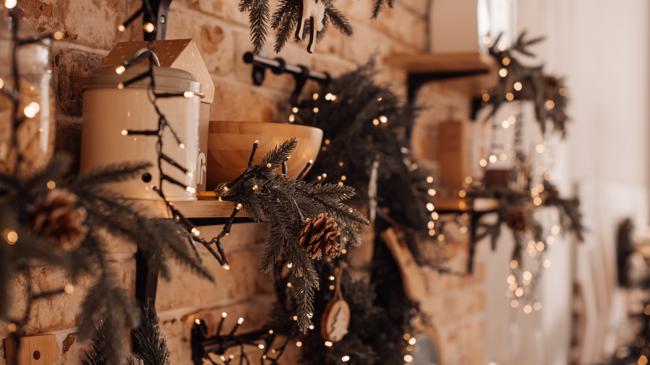 A wooden mantle covered in candles and Christmas decorations