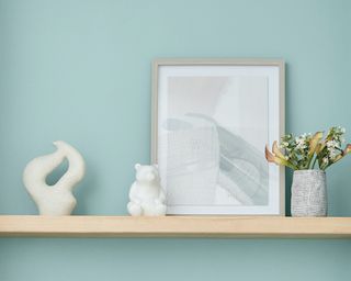 valspar renew blue with a wood shelf and accessories like a picture and plant