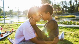 Young couple showing affection in a park - stock photo