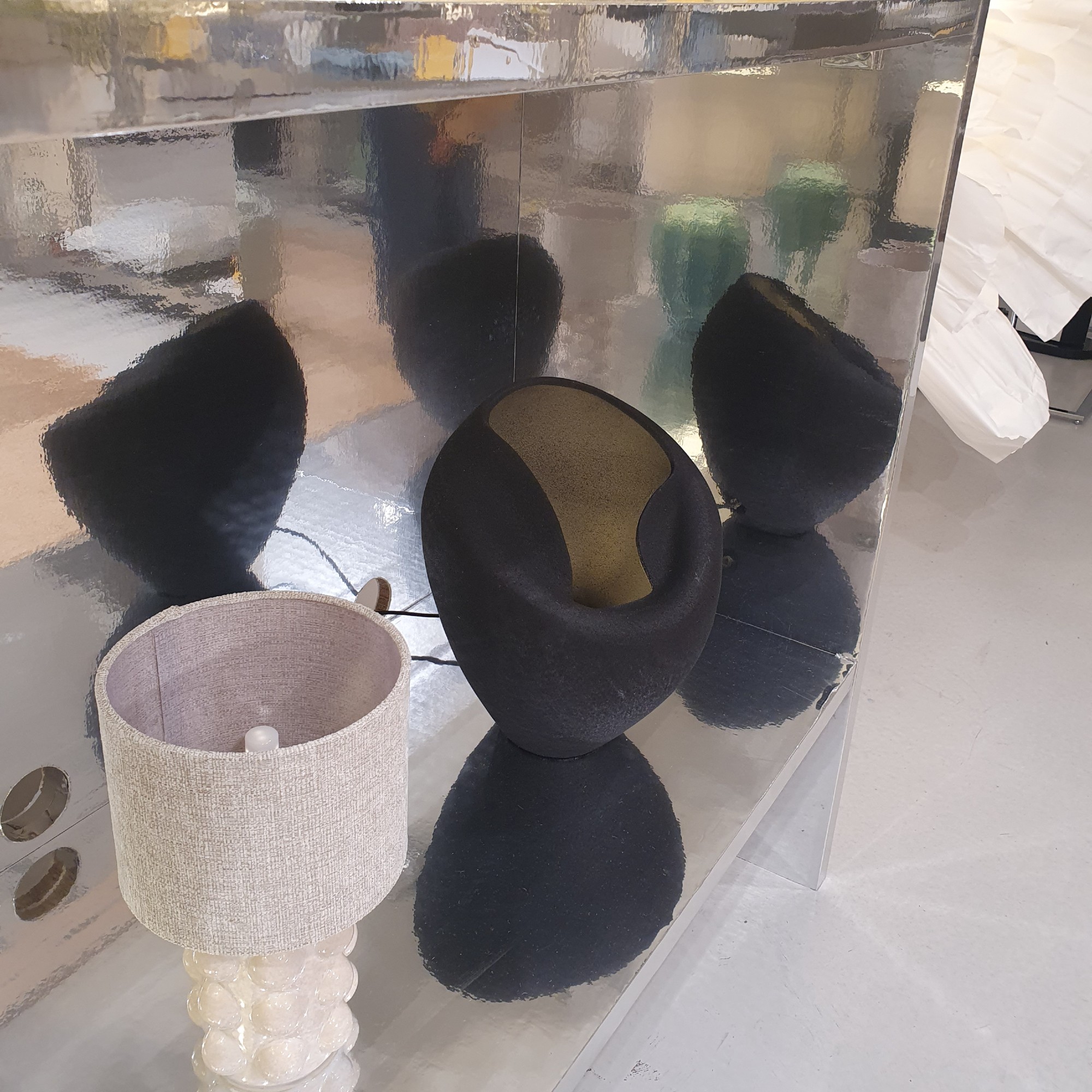 A mirror-finish shelving unit at the Next summer 2026 press preview displaying Next's table lamp including the N. Premium Isac table lamp in black